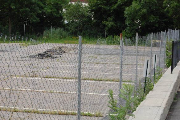 Parking lot at 75 New St. At right is driveway to Park 87 apartments.